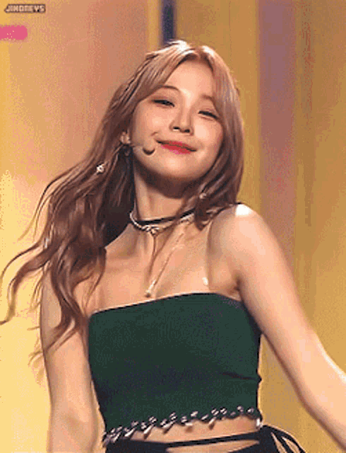 a woman is wearing a green crop top and a black choker .
