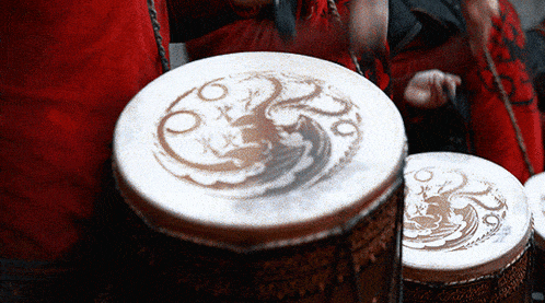 a close up of a drum with a dragon and the letter o on it