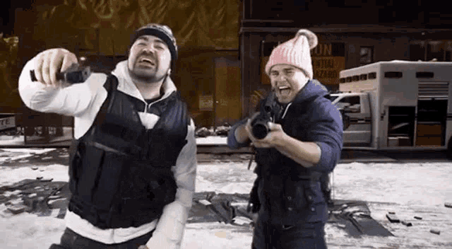 two men are standing next to each other holding guns in front of a building that says central hazard .