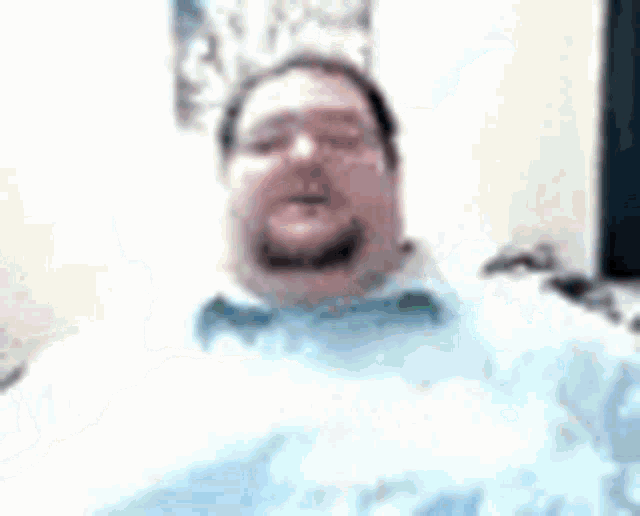 a man with a beard and glasses is making a funny face .
