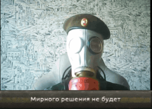 a man wearing a gas mask and a hat with a red star on it is sitting in front of a wall