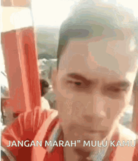 a close up of a man 's face with the words " jangan marah " written below it