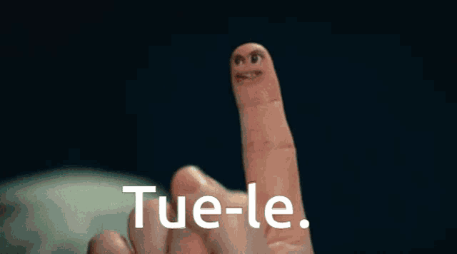 a man is sitting on a couch with the word tue-le written on the screen