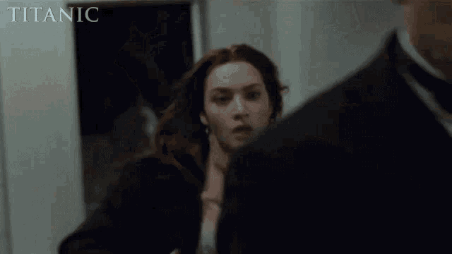 a woman is being held by a man in a tuxedo in a titanic movie scene