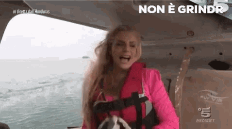 a woman in a life jacket is on a boat and says non è grindr