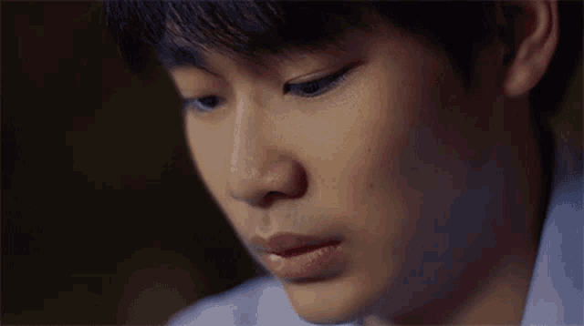 a close up of a young man 's face with a sad look on his face