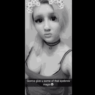 a black and white photo of a girl with a choker and a nose ring .