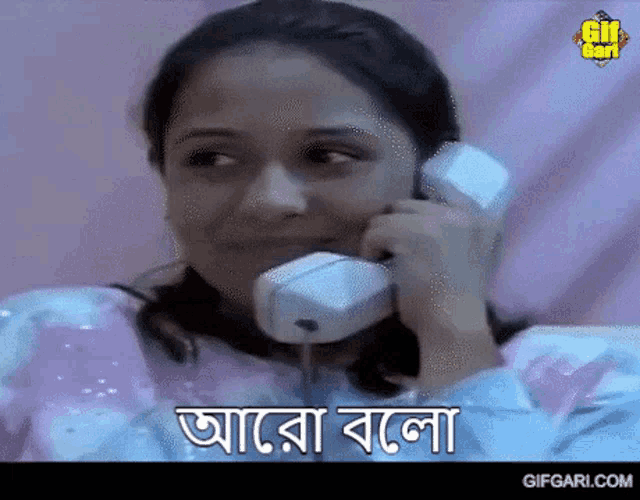 a woman is smiling while talking on a phone with the words " gifgari.com " at the bottom
