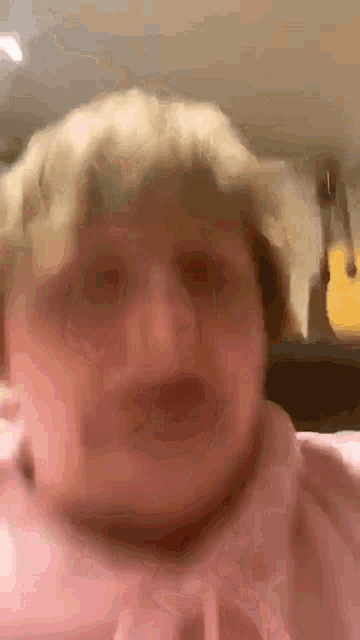 a close up of a person 's face with a guitar hanging in the background .