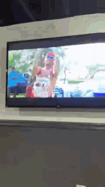 a tv screen shows a man in a red and white shirt