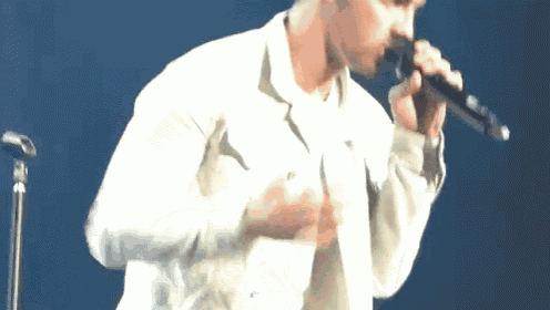 a man singing into a microphone on a stage