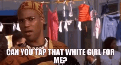 a man is standing in front of clothes hanging on a clothes line and says can you tap that white girl for me ?