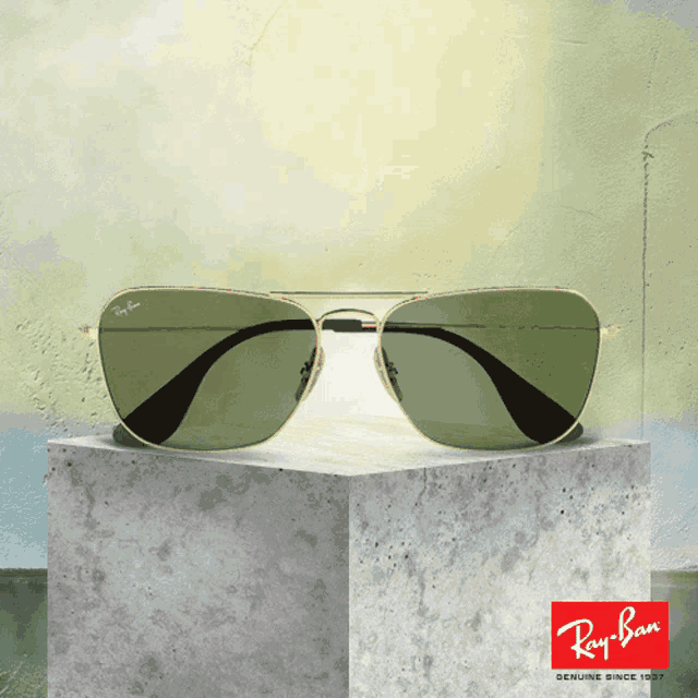 a pair of ray ban sunglasses sitting on a concrete block