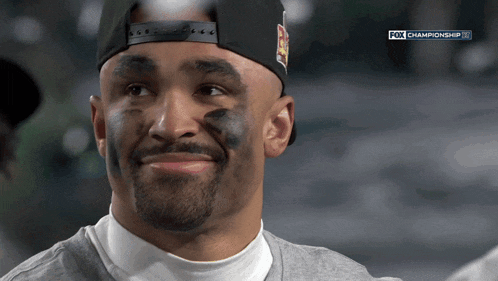 a man with black paint on his face is watching a fox championship game