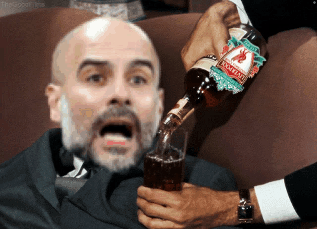a man in a suit is being poured a drink from a bottle that says ' mountain ' on it
