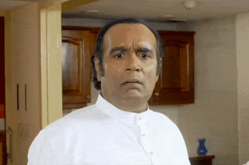 a man in a white shirt is making a face