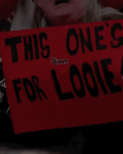 a woman holds up a red sign that says this one 's for loonie