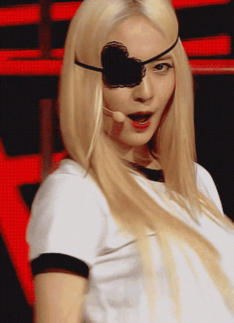 a woman wearing a white shirt and a black eye patch