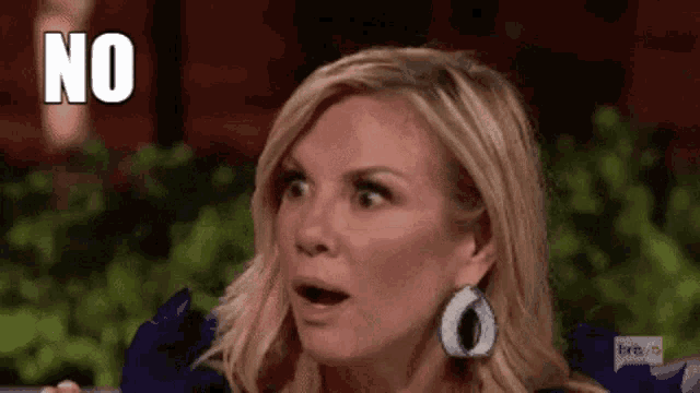 a woman with a surprised look on her face is holding her mouth open and saying no .