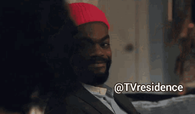 a man wearing a red hat and a suit is smiling with the words @tvresidence above him