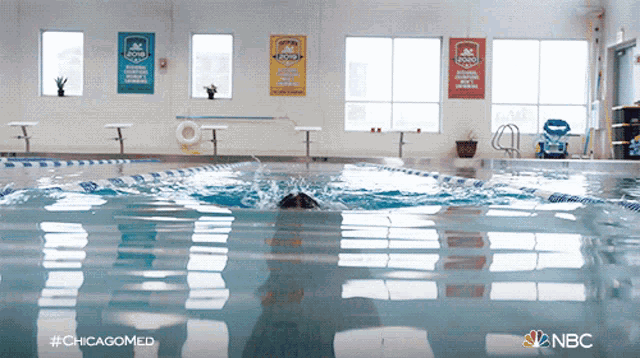 a person is swimming in a pool with a sign that says chicago on it