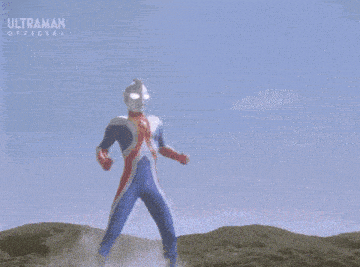 a cartoon character from ultraman is standing in a field with a blue sky in the background .