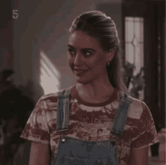 a woman is wearing overalls and a t-shirt with the number 5 on it