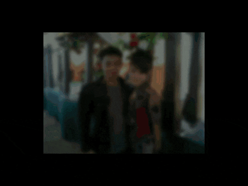 a blurry picture of a man and a woman with an e on the bottom left