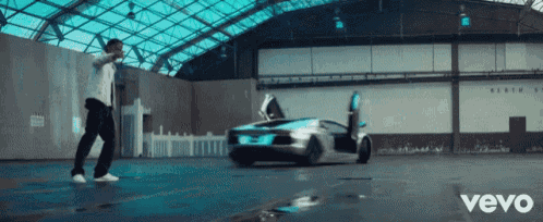 a man stands in front of a car with the word vevo on the bottom