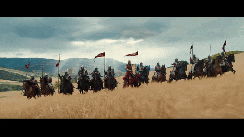 a group of knights are riding horses through a field