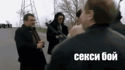 a group of men are standing next to each other on a street .