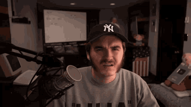 a man wearing a ny hat and a gray shirt