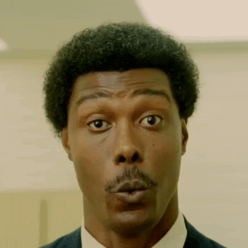 a man with a surprised look on his face wearing a suit and tie