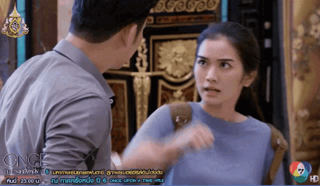 a man and a woman are fighting in front of a tv screen that says once