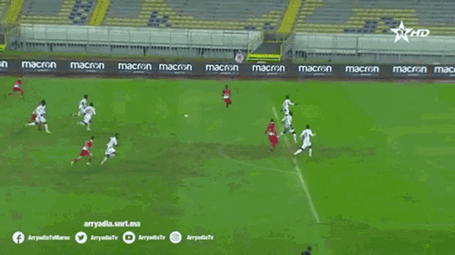 a soccer game is being played on a field with a banner that says macron on it