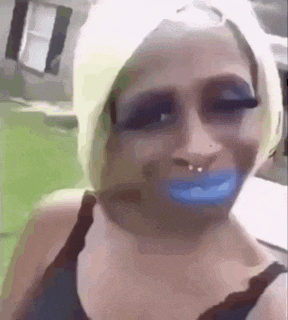 a woman with blue lips and a nose ring is wearing makeup .