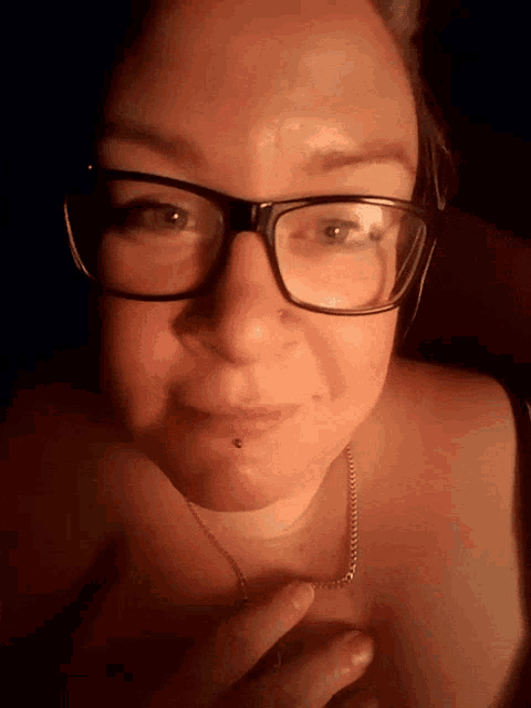 a close up of a woman wearing glasses and a chain around her neck