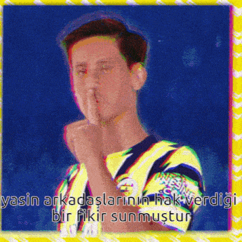 a man in a yellow shirt is holding his finger to his mouth .