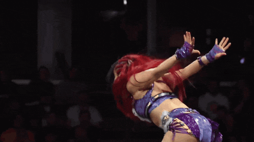 two women are wrestling in a ring with a referee behind them