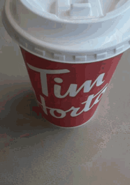 a tim hortons cup with a white lid on a table