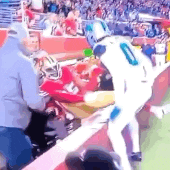 a football player is being helped off the field by a man in a mascot costume .