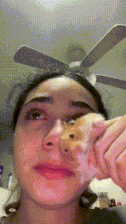 a woman holding a hamster in front of her face