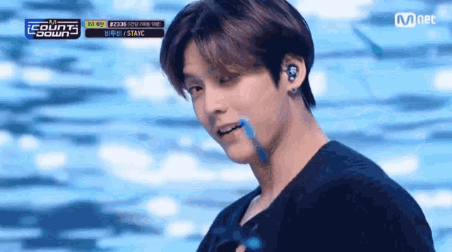 a close up of a person 's face with a mnet logo in the background .