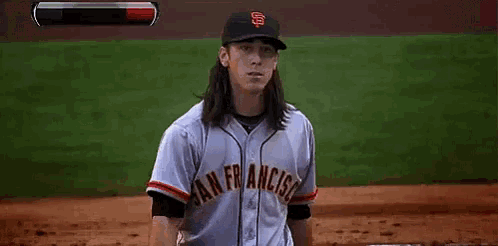 a man with long hair is wearing a san francisco baseball jersey