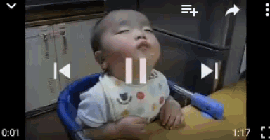 a baby is sitting in a high chair with his eyes closed .