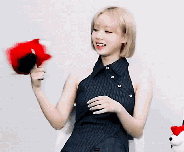 a woman in a black striped dress is holding a stuffed animal .