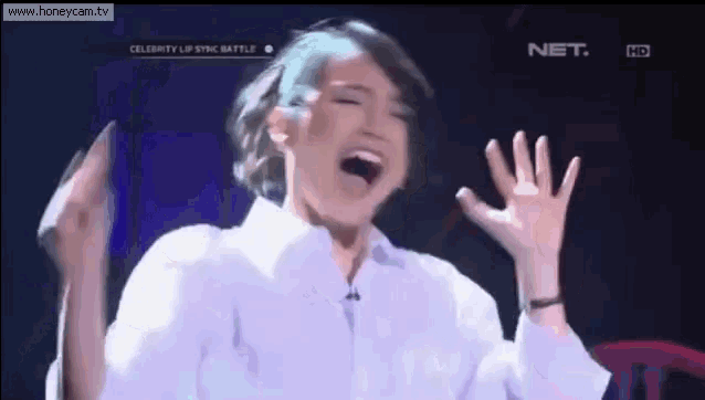 a woman in a white shirt is screaming on a television show