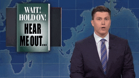 a man in a suit stands in front of a sign that says " wait hold on hear me out "