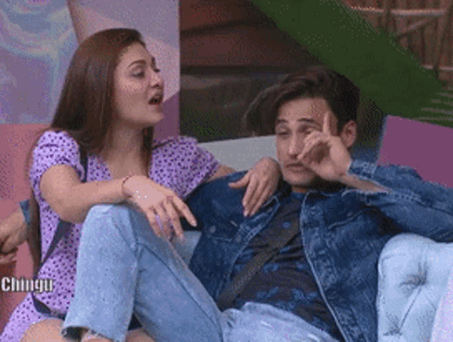 a man and a woman are sitting on a couch and talking to each other