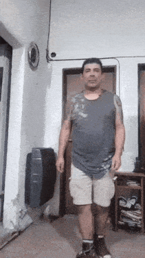 a man with a tattoo on his arm is standing in a room